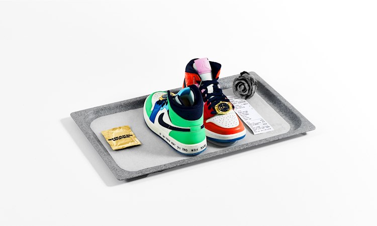 Nike sneakers on food tray alongside wipe, rose and receipt 